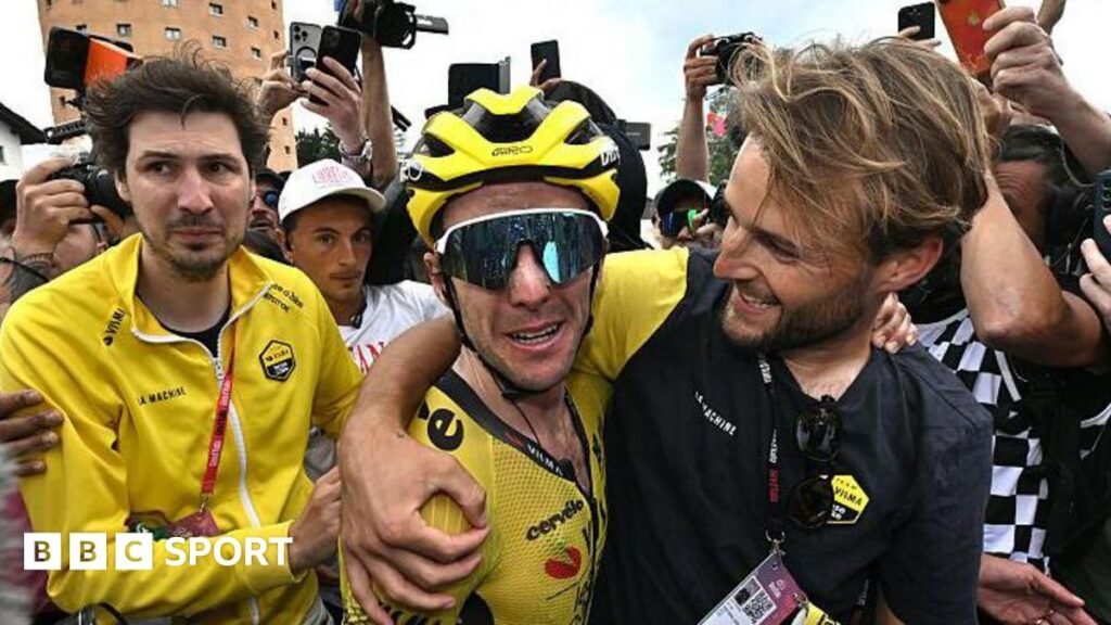 Simon Yates is hugged by a member of the Visma-Lease A Bike team staff after taking the lead in the 2025 Giro d'Italia