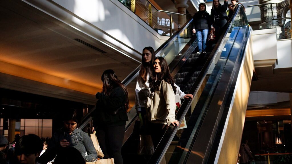 Shoppers ride down an escalator at Somerset Mall