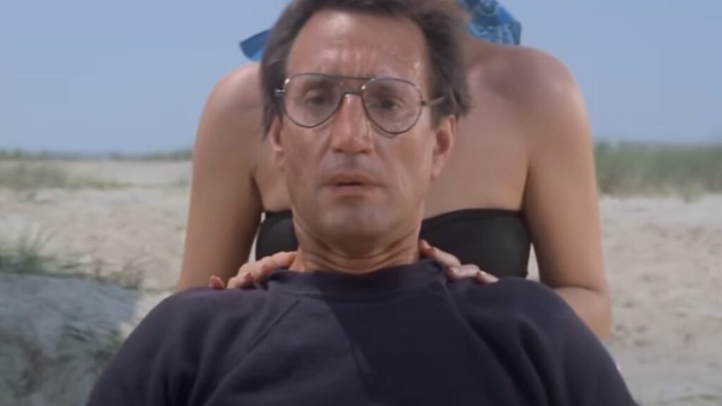A shark scientist reflects on Jaws at 50 closeup of man in glasses on the beach looking out to the water with growing horror