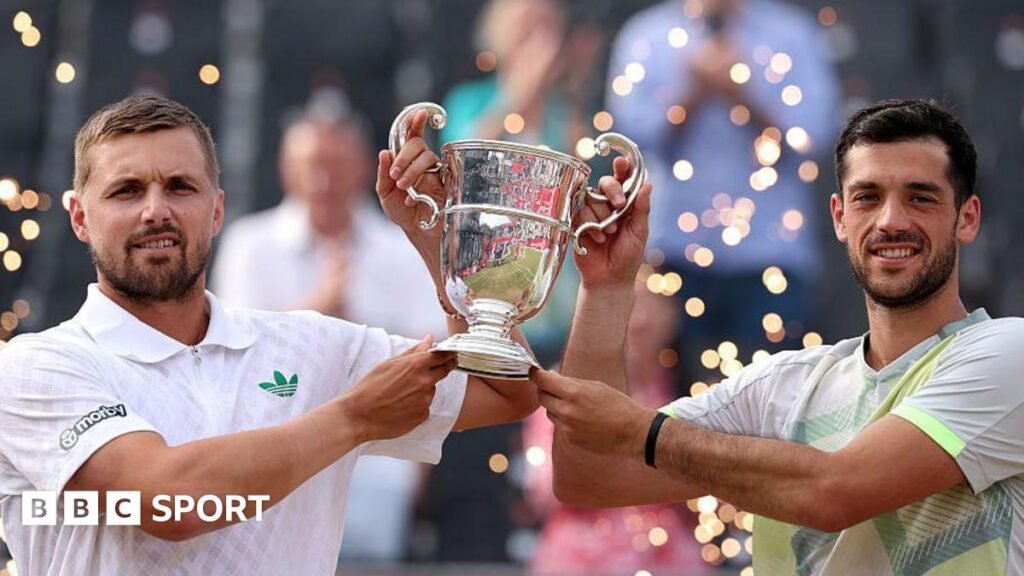Lloyd Glasspool and Julian Cash hold the men's doubles trophy at Queen's