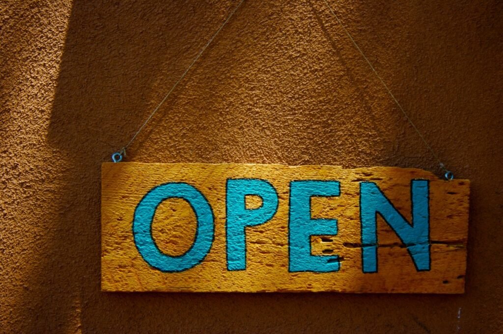A wooden, hand-painted "Open" sign