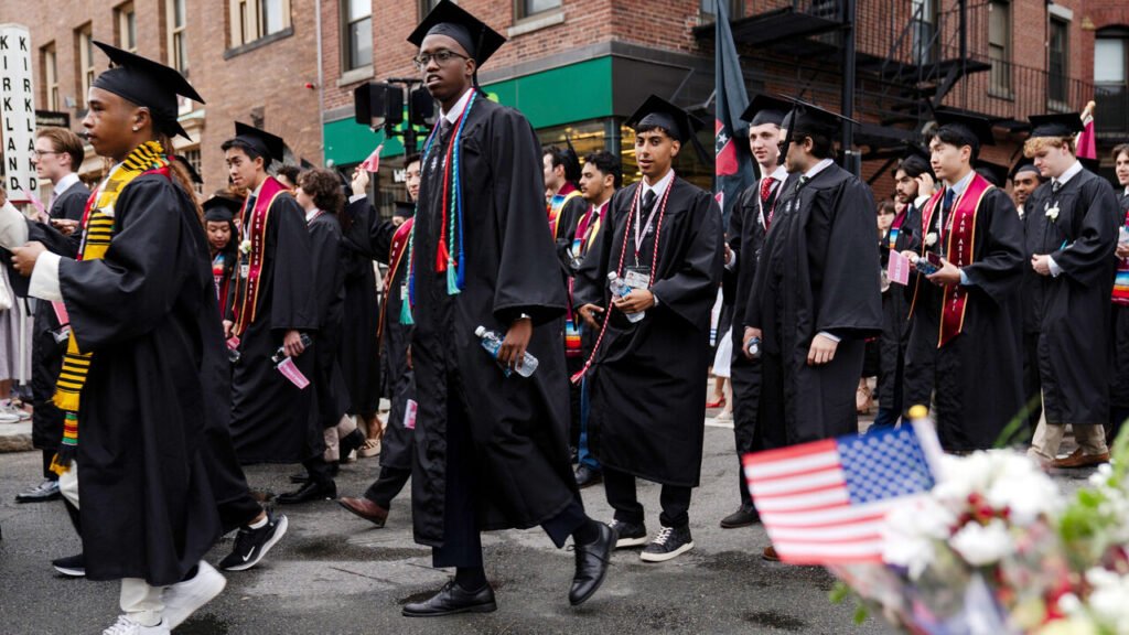 Graduates walk onto the Harvard campus for the university's 374th commencement.