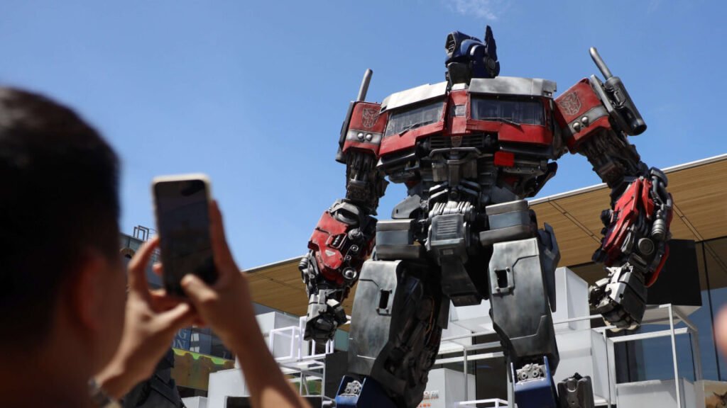 Photograph of a person taking a photograph of Optimus Prime