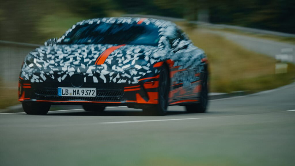 A camouflaged mercedes prototype drives towards the camera, there is motion blur
