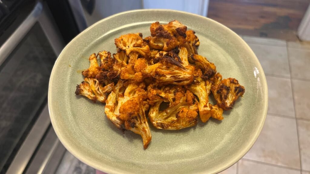 a green plate with cauliflower on it