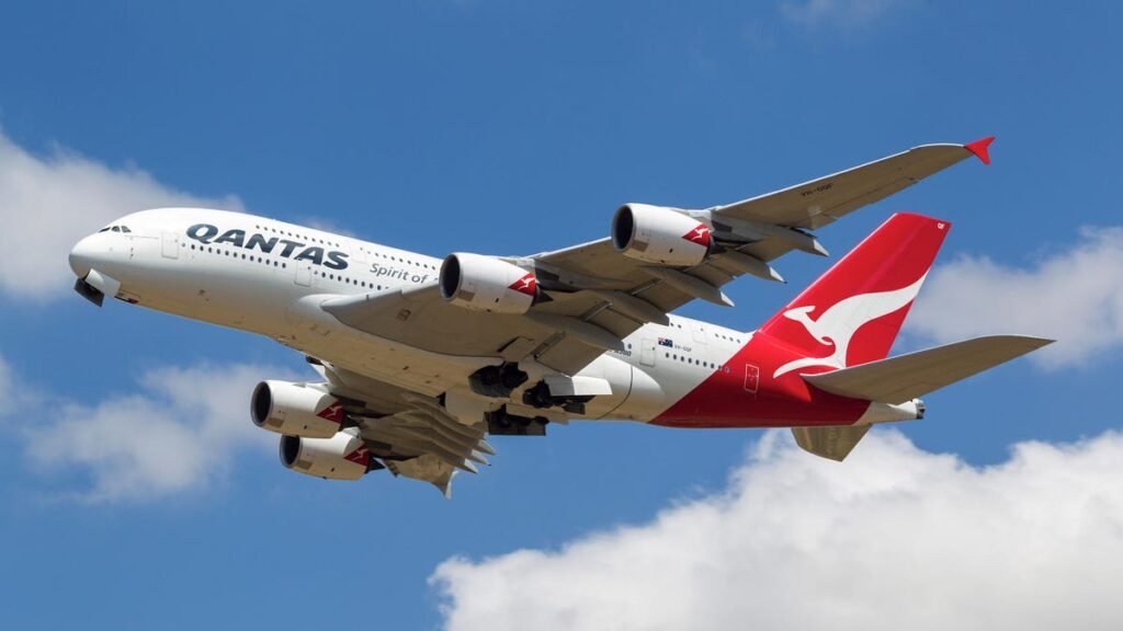 Qantas airplane in the sky on a sunny day.