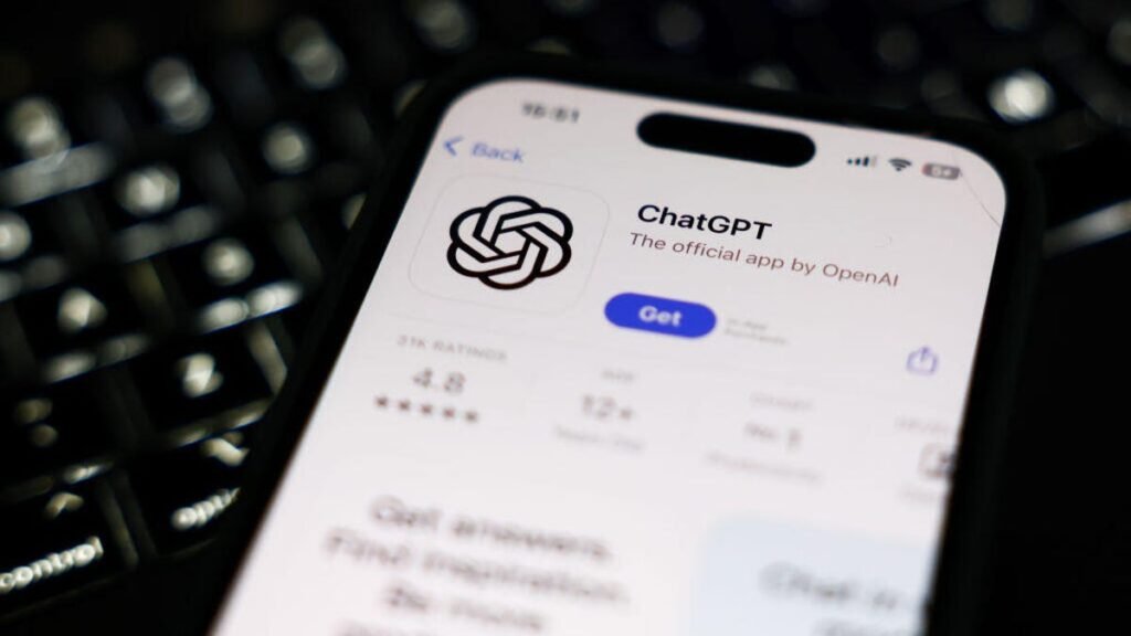 A phone with the ChatGPT app open in the App Store laying on top of a keyboard.